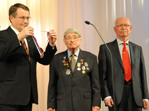 В.Костюков и Р.Илькаев вручают Ю.Трутневу знак отличия за выдающиеся достижения